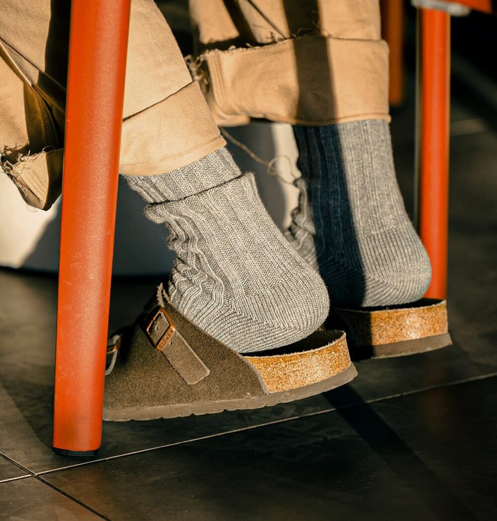 Close-up of grey urban ribbed socks paired with sandals.